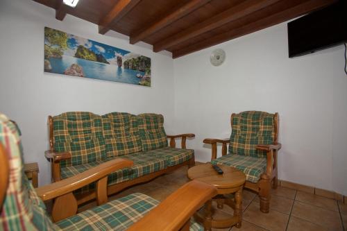 ein Wohnzimmer mit 2 Stühlen und einem Sofa in der Unterkunft Casa Criseva II in Avín
