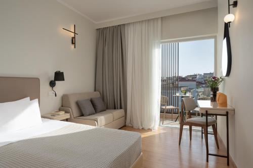 Preveza City Comfort Hotel في بريفيزا: غرفة نوم بسرير وطاولة واريكة