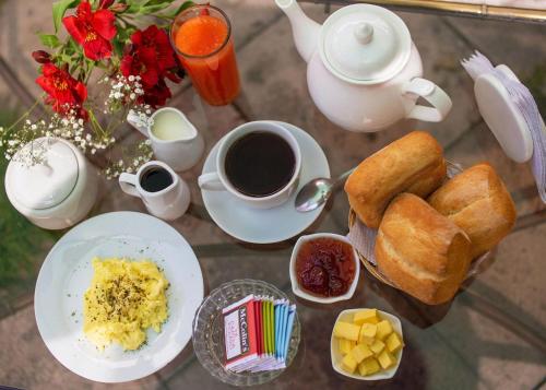 een glazen tafel met ontbijtproducten en koffie erop bij La Compañía de Jerusalen in Arequipa