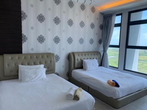 a bedroom with two beds and a window at ATLANTIS@MELAKA BY SWEETSTAY in Melaka