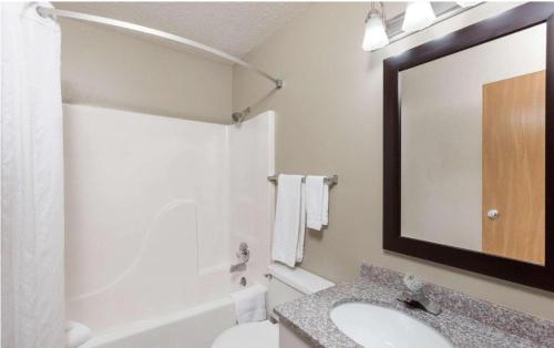 a bathroom with a sink and a mirror at Super 8 by Wyndham Manhattan KS in Manhattan