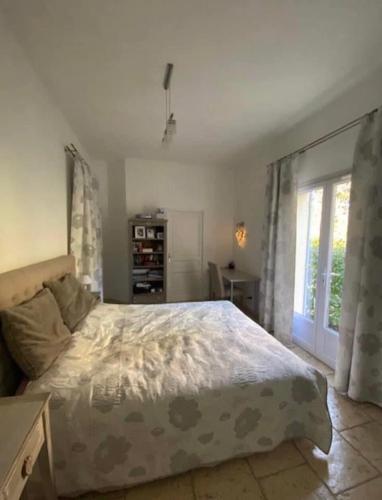 une chambre avec un grand lit et une fenêtre dans l'établissement Villa du Soleil en Provence sur le Domaine du Golf de Pont Royal, à Mallemort