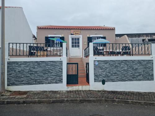 uma casa com dois portões em frente em "Apartamentos do Farol" com vista para o mar em Santa Cruz das Flores