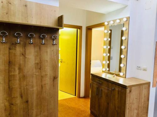 a bathroom with a wooden vanity and a mirror at Joy City Stay Victoriei 7G-3 in Timişoara