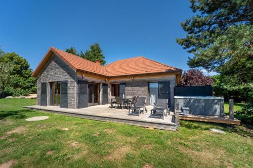 una casa con terraza y sillas en un patio en Les Lodges du Morvan, en Brazey-en-Morvan