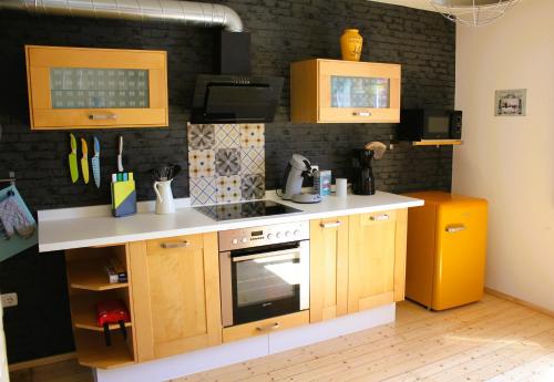 a small kitchen with wooden cabinets and a stove at Erholung am Vulkanradweg - 4 Sterne DTV Zertifiziert in Bad Salzschlirf