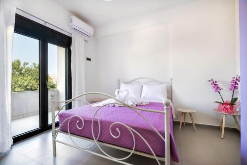 a bedroom with a bed with a purple blanket at Fotini 's apartment near the city center. in Chania