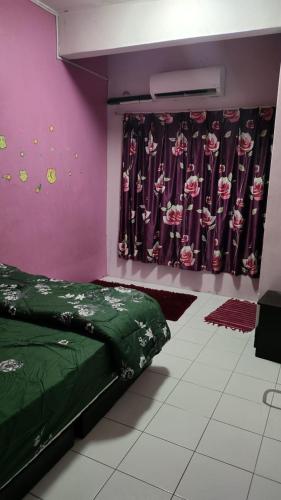 a bedroom with a green bed and a purple wall at Homestay D'chacha in Petaling Jaya