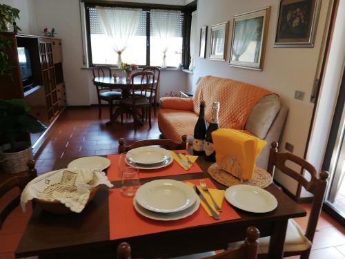 una sala de estar con una mesa con platos y botellas de vino en Appartamento Angela, en Riva del Garda