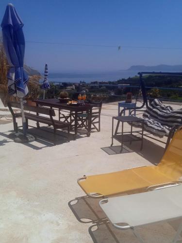a group of tables with umbrellas on a patio at Modern 1-bedroom with BBQ & Roof Garden near Beach in Stalos