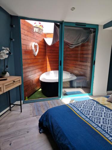 アミアンにあるStudio Eden Jacuzziの窓付きの部屋にバスタブ付きのベッドルームがあります。
