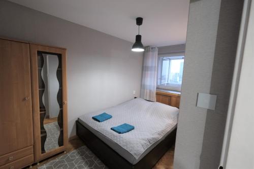 a small bedroom with a bed with blue pillows on it at Hey Apartments in Warsaw