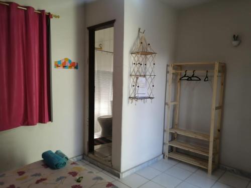a bathroom with a mirror and a red curtain at Aquarela Suítes in Piúma