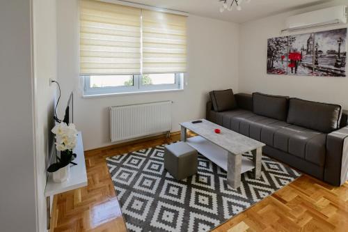sala de estar con sofá y mesa en Town side apartment, en Banja Luka