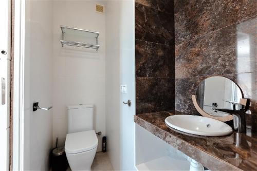 La salle de bains est pourvue d'un lavabo, de toilettes et d'un miroir. dans l'établissement House with Terrace and Shared Pool, à Mojácar