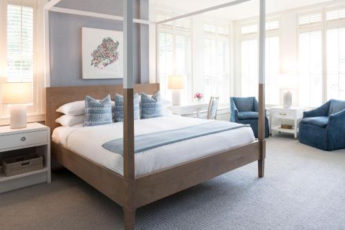 sypialnia z łóżkiem z baldachimem i niebieskim krzesłem w obiekcie Inns of Aurora Resort & Spa w mieście Aurora