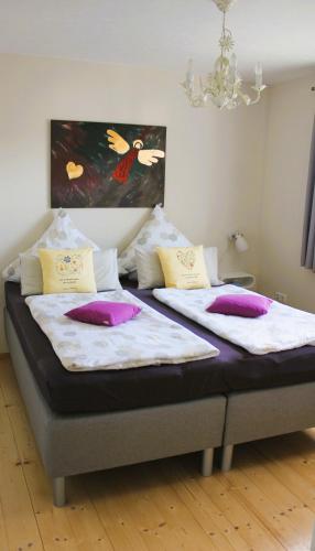 two twin beds in a room with a painting on the wall at Erholung am Vulkanradweg - 4 Sterne DTV Zertifiziert in Bad Salzschlirf