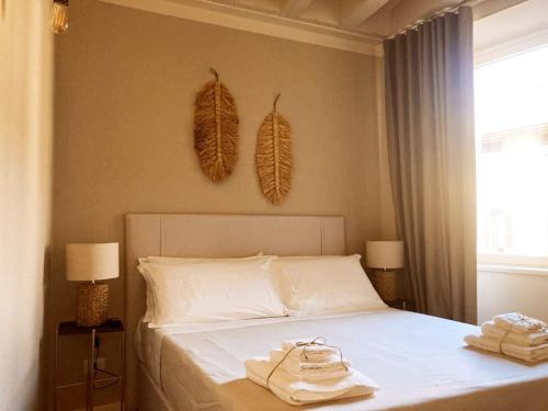 Gatto Bianco Bergamo Apartment في بيرغامو: غرفة نوم عليها سرير وفوط