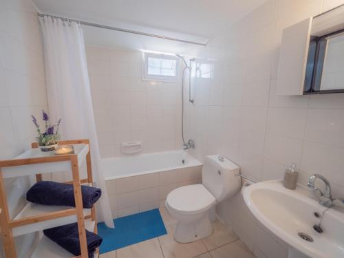 a bathroom with a toilet and a tub and a sink at The Salnik Beach Apartment in Limassol