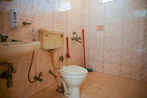 ein Bad mit einem WC und einem Waschbecken in der Unterkunft Ronne's 2BHK Lagoon Apartment -Calangute in Calangute