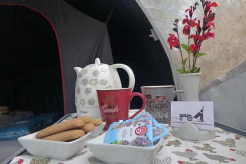 a table topped with cups and a plate of cookies at Capalbio Campeggio Rurale in Capalbio