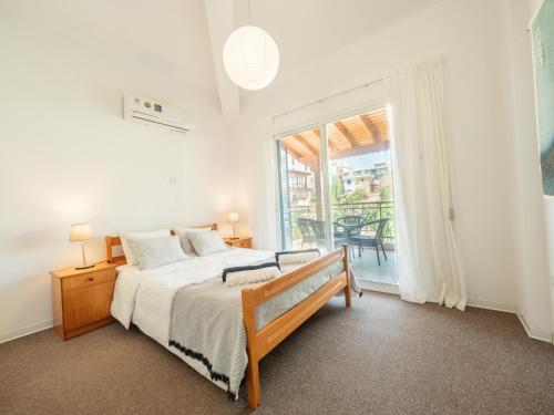 a bedroom with a bed and a large window at The Salnik Beach Apartment in Limassol