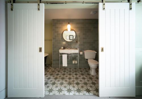 a bathroom with a toilet and a sink at Eleven Didsbury Park Hotel in Manchester