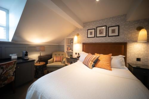 a bedroom with a large white bed and a chair at Eleven Didsbury Park Hotel in Manchester