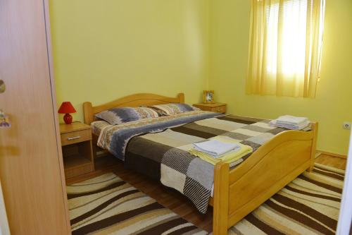 a bedroom with a bed with two night stands and a window at Kuca za odmor Dragina in Perućac