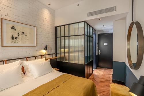 a bedroom with a bed and a large window at Backstage Hotel - an Atlas Boutique Hotel in Tel Aviv