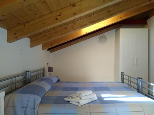 a bedroom with a bed with towels on it at Dreaming Feriolo - mansarded apartment by Danilo Apartments in Baveno