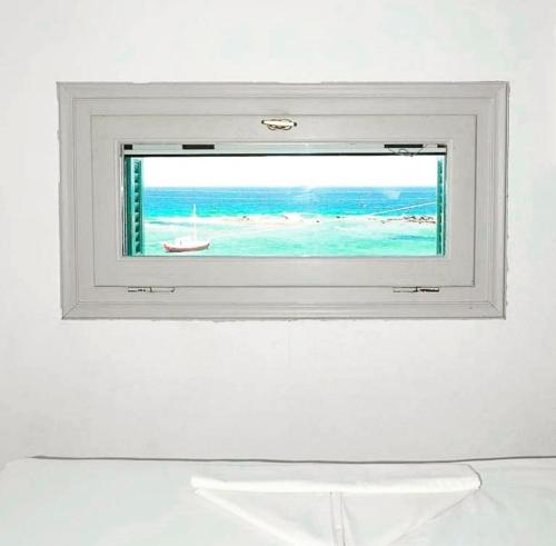 a window with a view of the beach at Anemoessa Studios in Pollonia