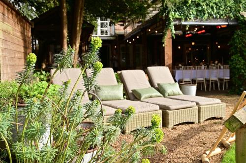 a group of wicker chairs sitting on a patio at Eleven Didsbury Park Hotel in Manchester