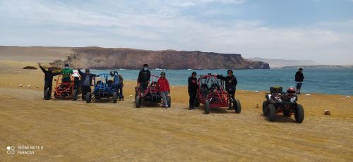 a group of people standing on the beach with their motorcycles at Hostal Mendieta in Paracas
