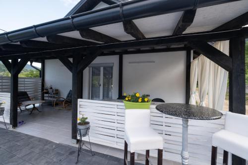 un patio con tavolo e sedie sotto un pergolato di Vikendica Lohovo a Bihać