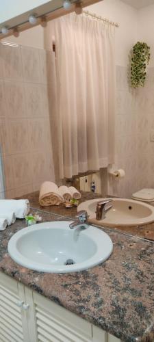 a bathroom counter with a sink and a mirror at Villa da Rosa in Olbia