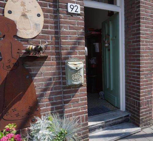 a cat is sitting on the side of a brick building at De bezige bij in Kerkrade