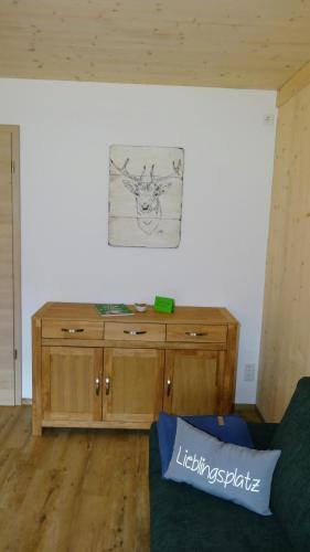 a drawing on the wall above a wooden cabinet at WaldBlick im Happy Allgäu - Wohnung mit großer Dachterrasse in Leutkirch im Allgäu