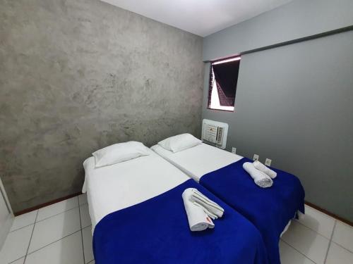 1 dormitorio con 1 cama con sábanas blancas y azules en Apartamento Ponta Verde-Pajuçara - Edf-Soho 2 Quartos - Castelo B Temporada, en Maceió