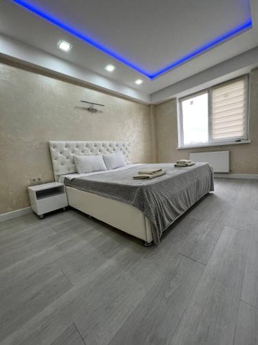 a bedroom with a large bed with a blue ceiling at LuxRent in Chişinău