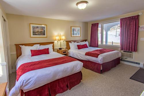 ノースコンウェイにあるEastern Slope Inn Resortのベッド2台と窓が備わるホテルルームです。
