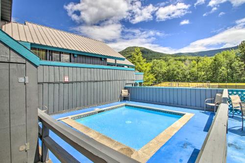 a swimming pool in the backyard of a house with a building at Cozy Lincoln Condo about 1 Mi to Loon Mountain! in Lincoln