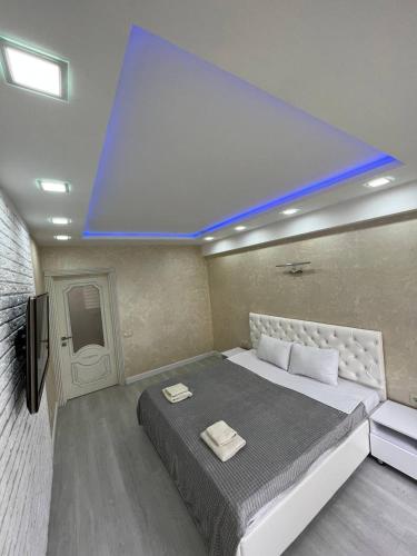 a bedroom with a large bed with a blue ceiling at LuxRent in Chişinău