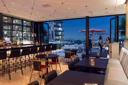 a restaurant with tables and chairs and a view of the city at The Godfrey Hotel Hollywood in Los Angeles