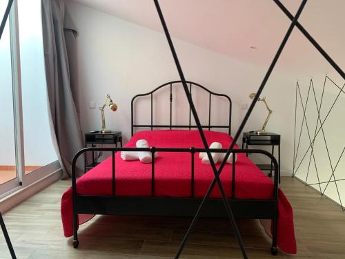 Un dormitorio con una cama roja con una manta roja. en CASA DAS CEGONHAS, en Faro