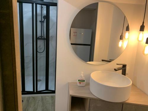 Un baño con un lavabo blanco y un espejo. en CASA DAS CEGONHAS, en Faro