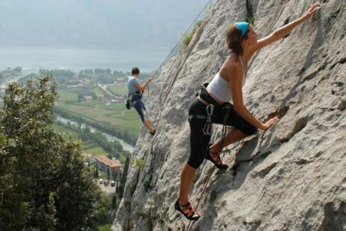 a man and a woman climbing on a rock at Casa Vacanze - Green Garden in Ledro