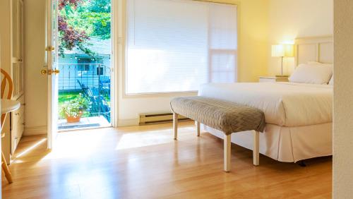 1 dormitorio con cama y ventana grande en The Village Motel, en Naramata