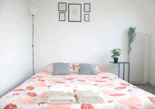 a bedroom with a large bed with a floral bedspread at Super studio proche de Paris Porte de Versailles ! in Vanves