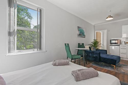 a bedroom with a bed and a table and chairs at Stunning studio flat with free on-street parking! in Plumstead